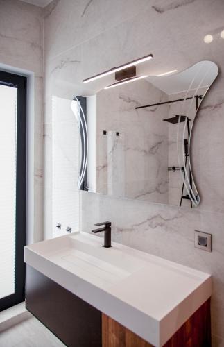a bathroom with a white sink and a mirror at Villa Dara and Todd in Sivota