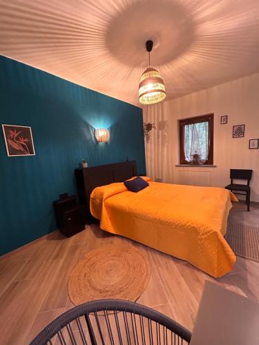 a bedroom with an orange bed and a blue wall at Giraluna in Demonte