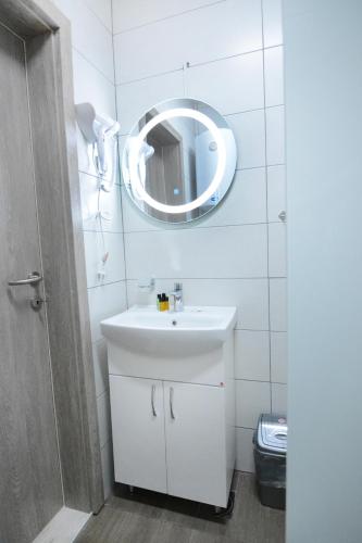 a bathroom with a white sink and a mirror at Leon Luxury Apartments in Ohrid
