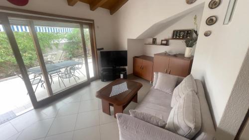 a living room with a couch and a balcony with a table at Arbe Downtown in Rab