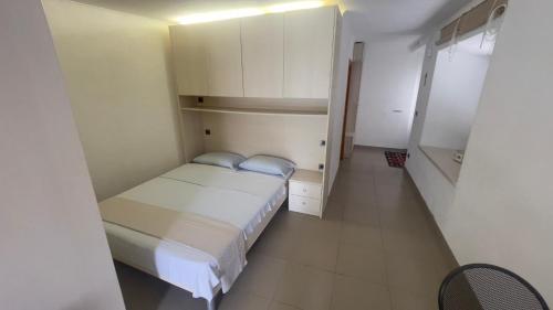 a small bedroom with a bed and white cabinets at Arbe Downtown in Rab