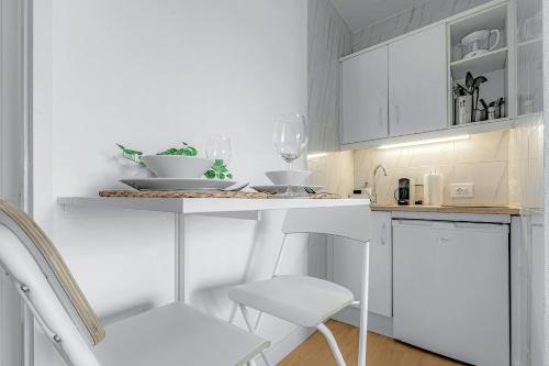 a white kitchen with white cabinets and a white chair at Estudio con vistas ciudad in Puerto de la Cruz