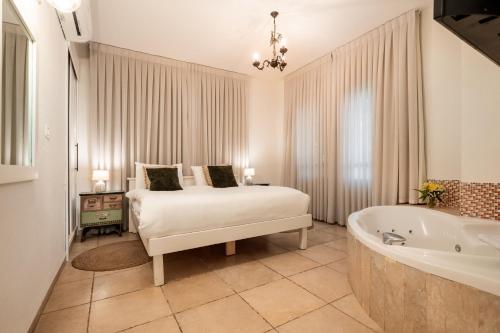a bedroom with a bed and a bath tub at Grand Vista Boutique Hotel And Spa in Yuval