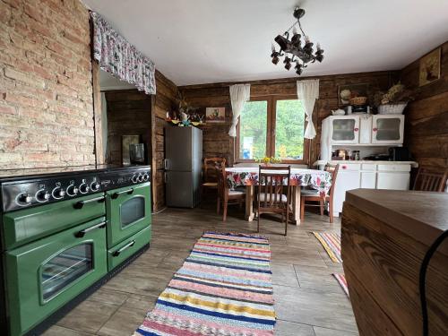 a kitchen with a green oven and a table at Osmolicka Chatka in Ryki