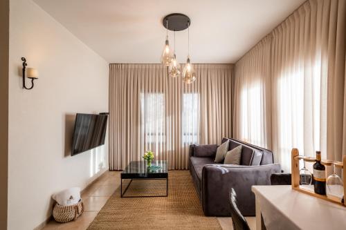 a living room with a couch and a table at Grand Vista Boutique Hotel And Spa in Yuval