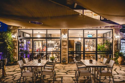a restaurant with tables and chairs in front of a building at Grand Vista Boutique Hotel And Spa in Yuval