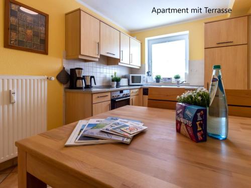 a kitchen with a wooden table with a bottle of wine at Haus Südstrand in Thiessow