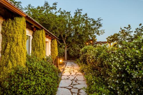 a stone path next to a house with trees at Grand Vista Boutique Hotel And Spa in Yuval