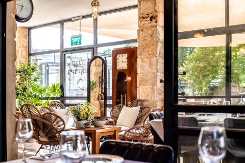 a restaurant with chairs and tables and windows at Grand Vista Boutique Hotel And Spa in Yuval