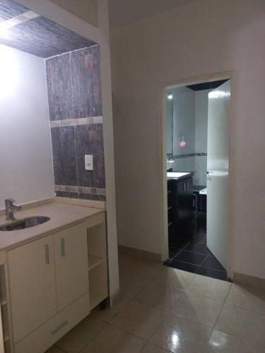 an empty kitchen with a sink and a hallway at La Casa de Los Mellis.. in La Banda