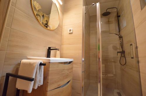 a bathroom with a shower and a sink and a mirror at Ginko House in Opatija