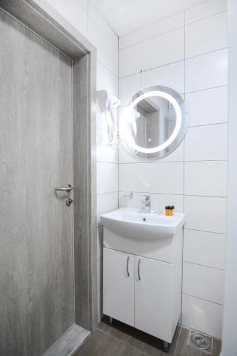 a white bathroom with a sink and a mirror at Leon Luxury Apartments in Ohrid