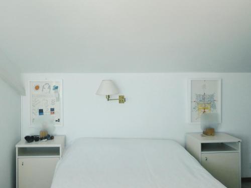 een witte slaapkamer met een bed en twee nachtkastjes bij Villa Marina in Brela