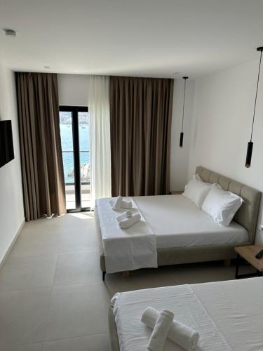 um quarto de hotel com uma cama e uma grande janela em Hotel Edola em Saranda