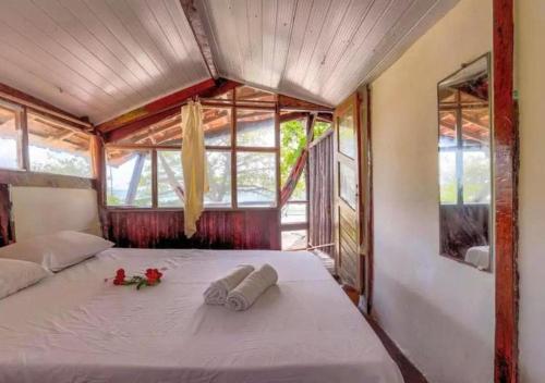 a bedroom with a bed with two towels on it at Pousada Boas Ondas in Itacaré