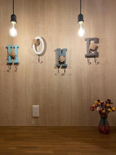 a room with a vase of flowers and lights on a wall at W&J Dream Stay in Osaka