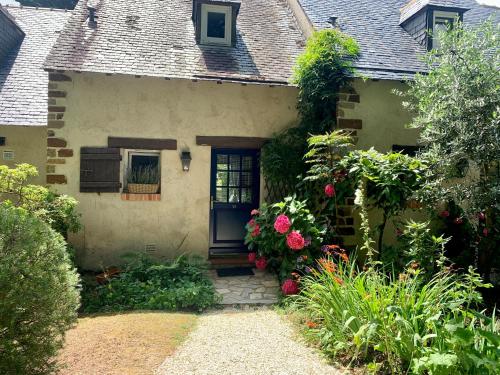 een huis met een deur en bloemen ervoor bij Cottage in Missillac