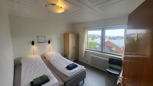 a hotel room with two beds and a window at Heart of the City (Hotel Bólið Guesthouse) in Tórshavn