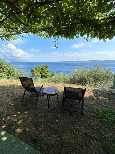 two chairs and a table with a view of the ocean at relax in Marusici 