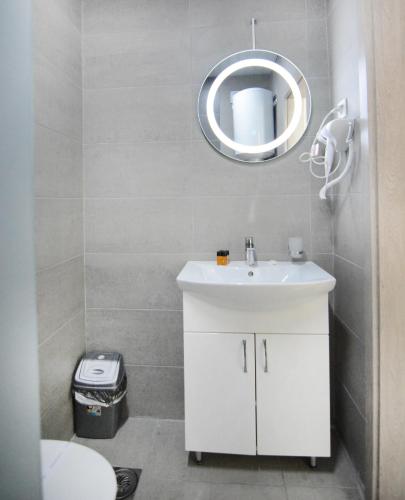 a bathroom with a white sink and a mirror at Leon Luxury Apartments in Ohrid