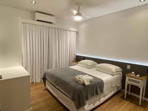a bedroom with a bed with two towels on it at Pousada Armação de Camburi in Camburi
