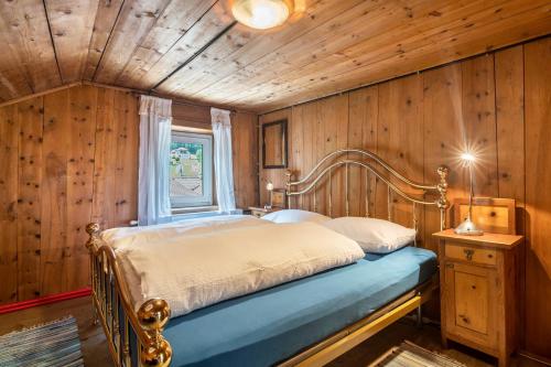 a bedroom with a bed in a room with wooden walls at Enrich Apartment in Ortisei