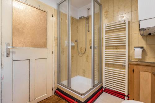 a shower with a glass door in a bathroom at Enrich Apartment in Ortisei