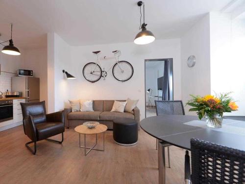a living room with a couch and a table with a bike on the wall at Ohlerich Speicher App_ 07 in Wismar