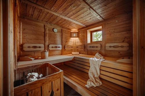 a wooden interior of a sauna with benches and a window at Almdorf Reiteralm in Schladming