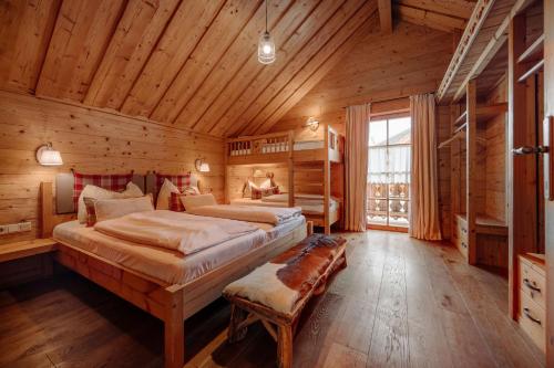 a bedroom with two beds in a log cabin at Almdorf Reiteralm in Schladming