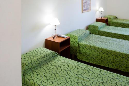 um quarto de hotel com duas camas e uma mesa em El Amparo Hotel em San Luis