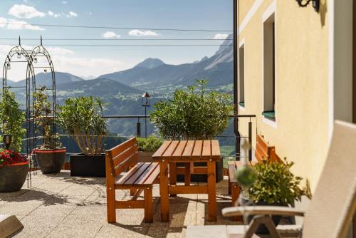 a patio with a wooden table and benches on a balcony at Apparthaus Taxegger in Haus im Ennstal