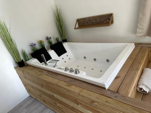 La salle de bains est pourvue de parquet et d'une baignoire blanche. dans l'établissement Studio SPA Balnéo - Jardin privé, à Maureilhan-et-Raméjan