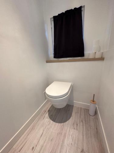 a bathroom with a toilet with a black curtain at Studio SPA Balnéo - Jardin privé in Maureilhan-et-Raméjan