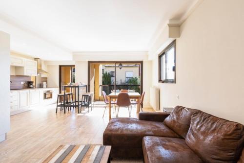 a living room with a leather couch and a table at Beautiful furnished apartment in a private Residence with Pool in Cannes