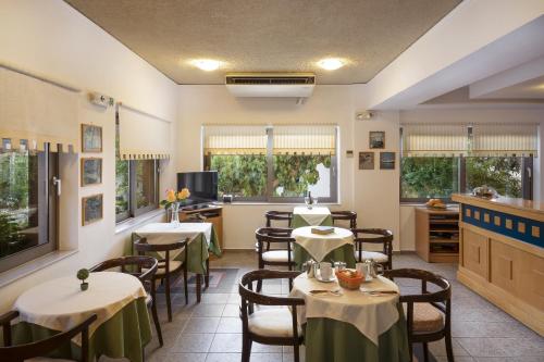 パレオコラにあるRea Hotelのテーブルと椅子が備わるレストラン