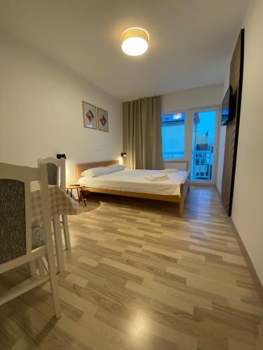 a bedroom with a bed and a large window at Apart-pansion Promajna in Promajna