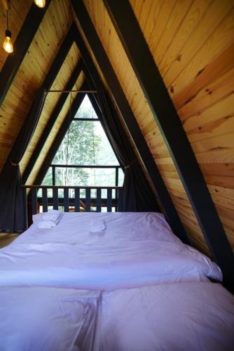 a large bed in a wooden room with a window at LUSER BUNGALOW in Ardeşen