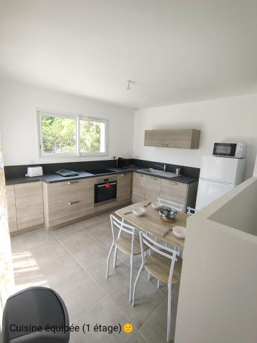 une cuisine avec une table et des chaises dans l'établissement La Villa Yucca Vias Plage - 300m plage et centre, à Vias