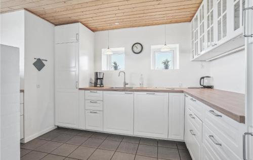 Nørre VorupørにあるStunning Home In Thisted With Kitchenの白いキャビネットと壁掛け時計付きのキッチン