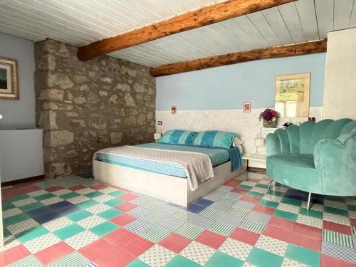 ein Schlafzimmer mit einem Bett und einem Stuhl in der Unterkunft Collina Blu in Bolsena