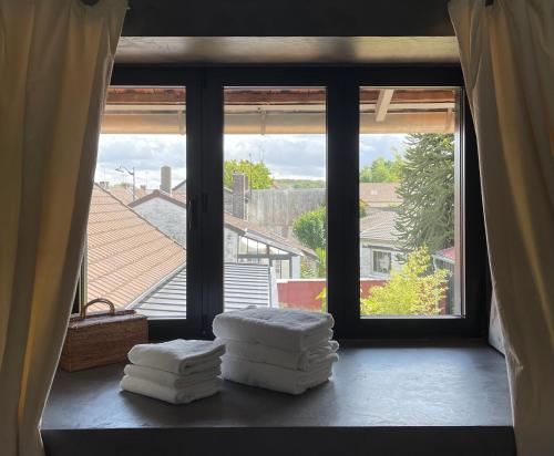 une chambre avec deux empilements de serviettes sur une fenêtre dans l'établissement Loft L'Écluse 1, parking gratuit, à Saint-Valery-sur-Somme