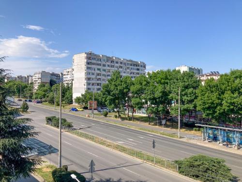 an empty road in a city with tall buildings at Уютен кът in Burgas