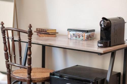 a table with a microwave on a shelf with a chair at Borgo Antico Rooms in Messina