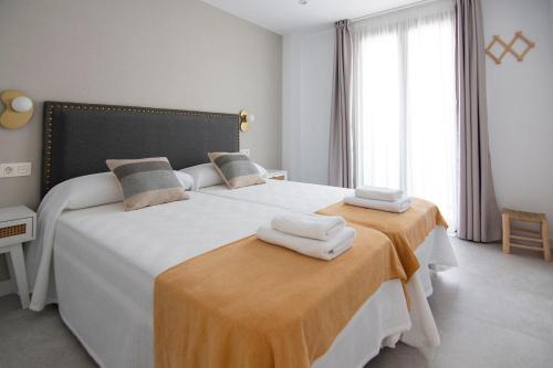 ein Schlafzimmer mit 2 Betten und Handtüchern darauf in der Unterkunft Clotilde Centro in Alcañiz