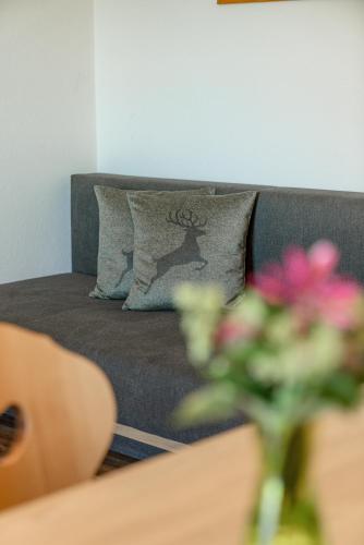 a couch with a pillow with a deer on it at Apparthaus Taxegger in Haus im Ennstal