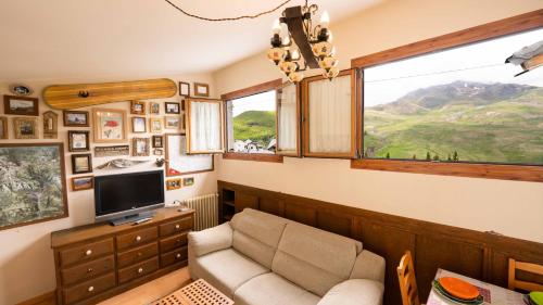 a living room with a couch and a tv and a window at Apartamentos Formigal - Admite mascotas- in Formigal