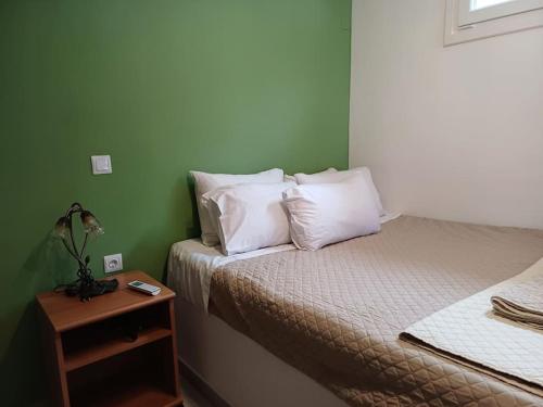 een slaapkamer met 2 bedden en een nachtkastje met een bed sidx sidx bij Liberty Roof House in Ermoupoli