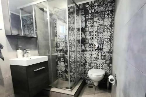 een badkamer met een douche, een toilet en een wastafel bij Liberty Roof House in Ermoupoli