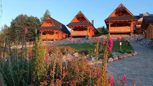 a group of wooden homes with flowers in front of them at Beskidzka Ostoja - Miejsce z duszą in Ustroń